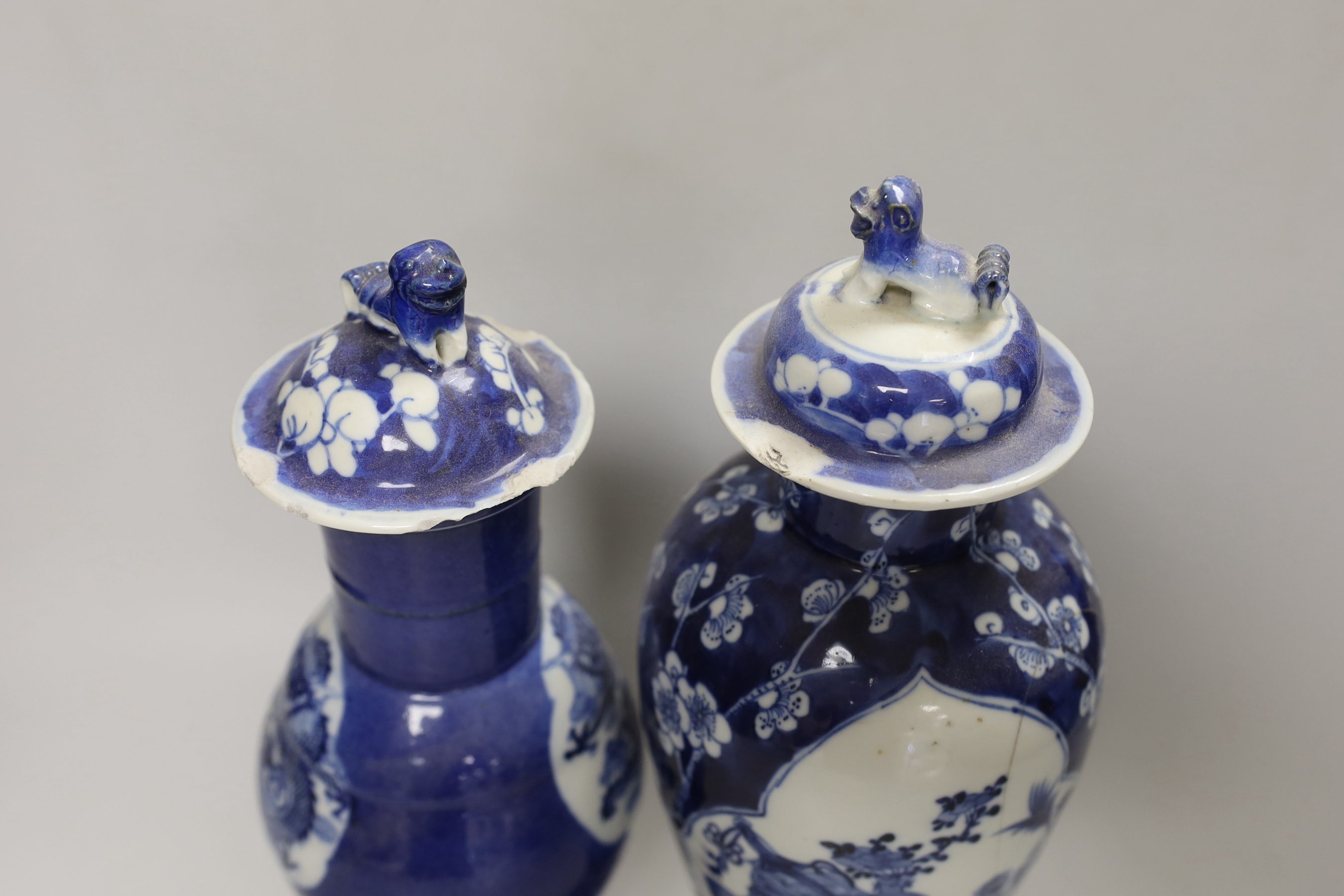 Two 19th century Chinese blue and white vases and covers, one with a dragon cartouche, the other a floral cartouche, tallest 34cm high